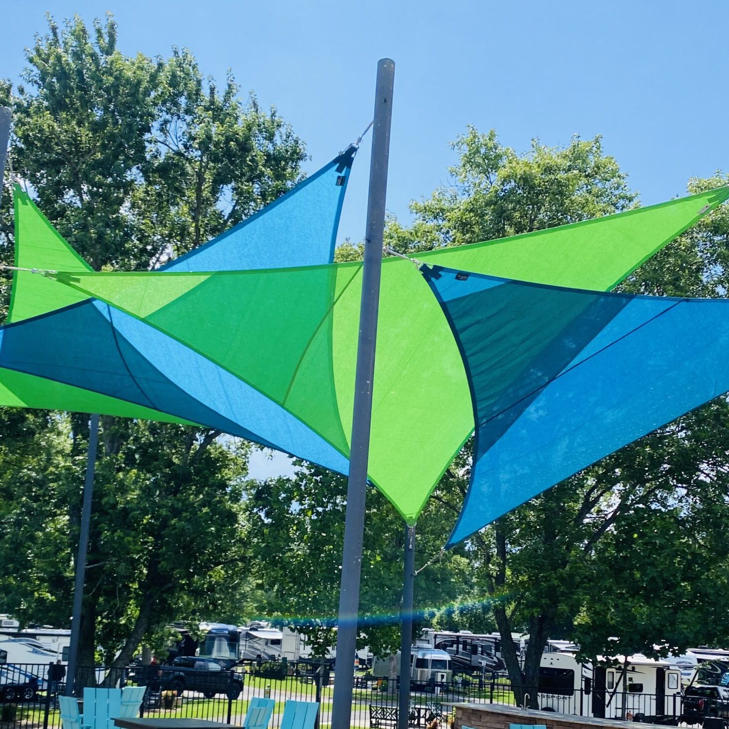 blue and green shade sails by pool